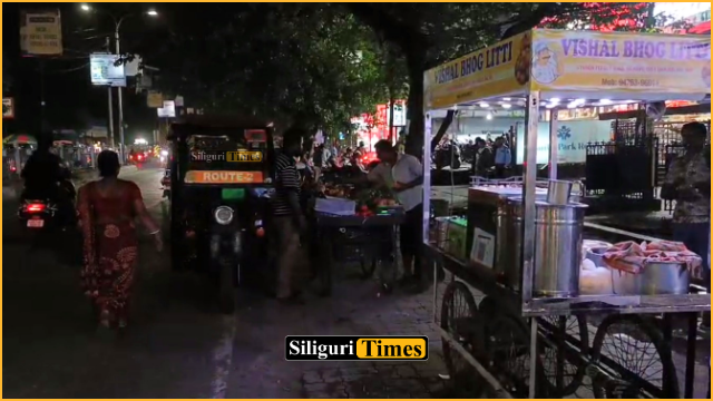 Shops occupy roadside parking space along Siliguri’s SF Road, forcing pedestrians onto main road